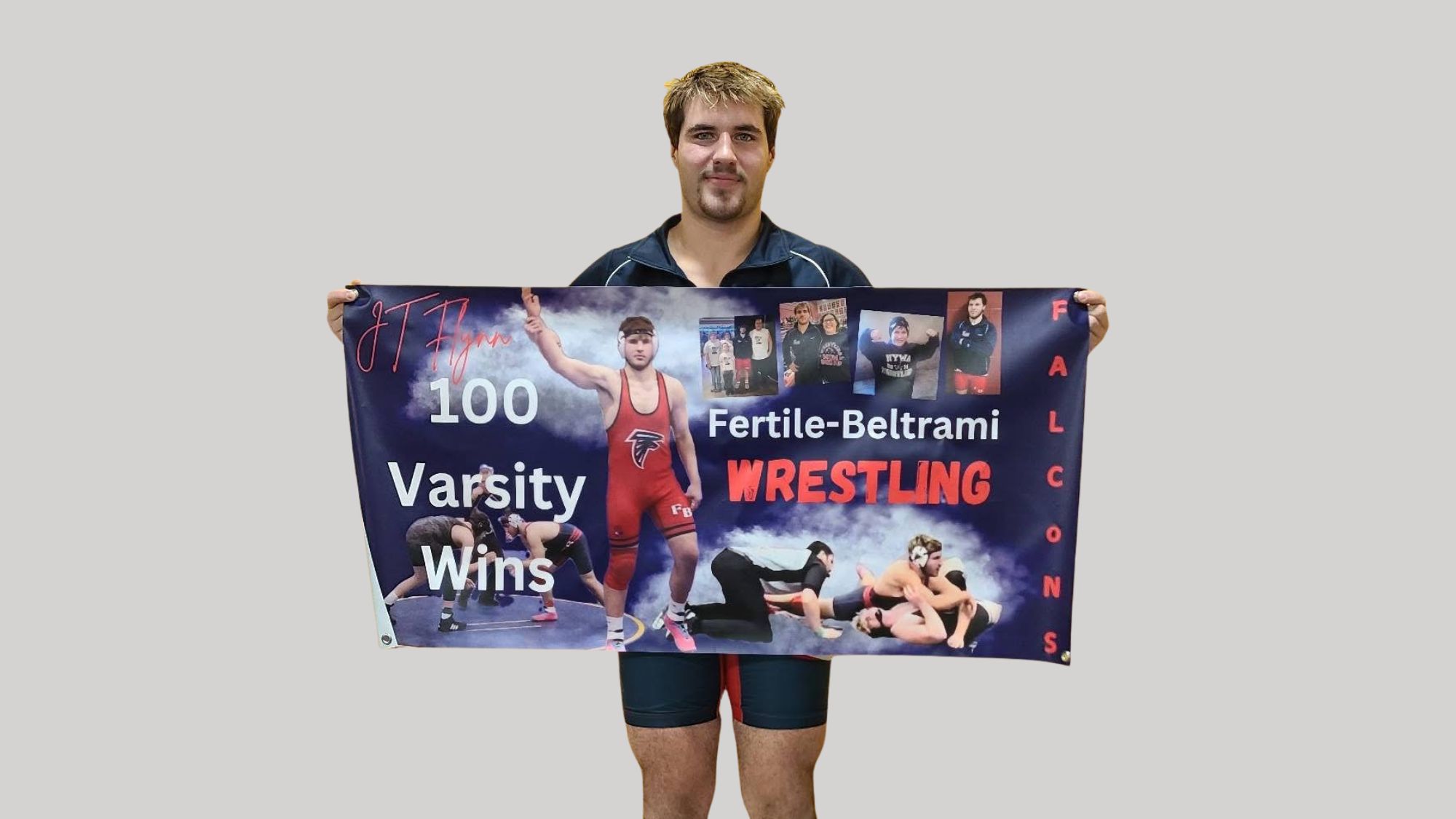 Photo of Jt Flynn holding his poster for getting his 100th varsity win